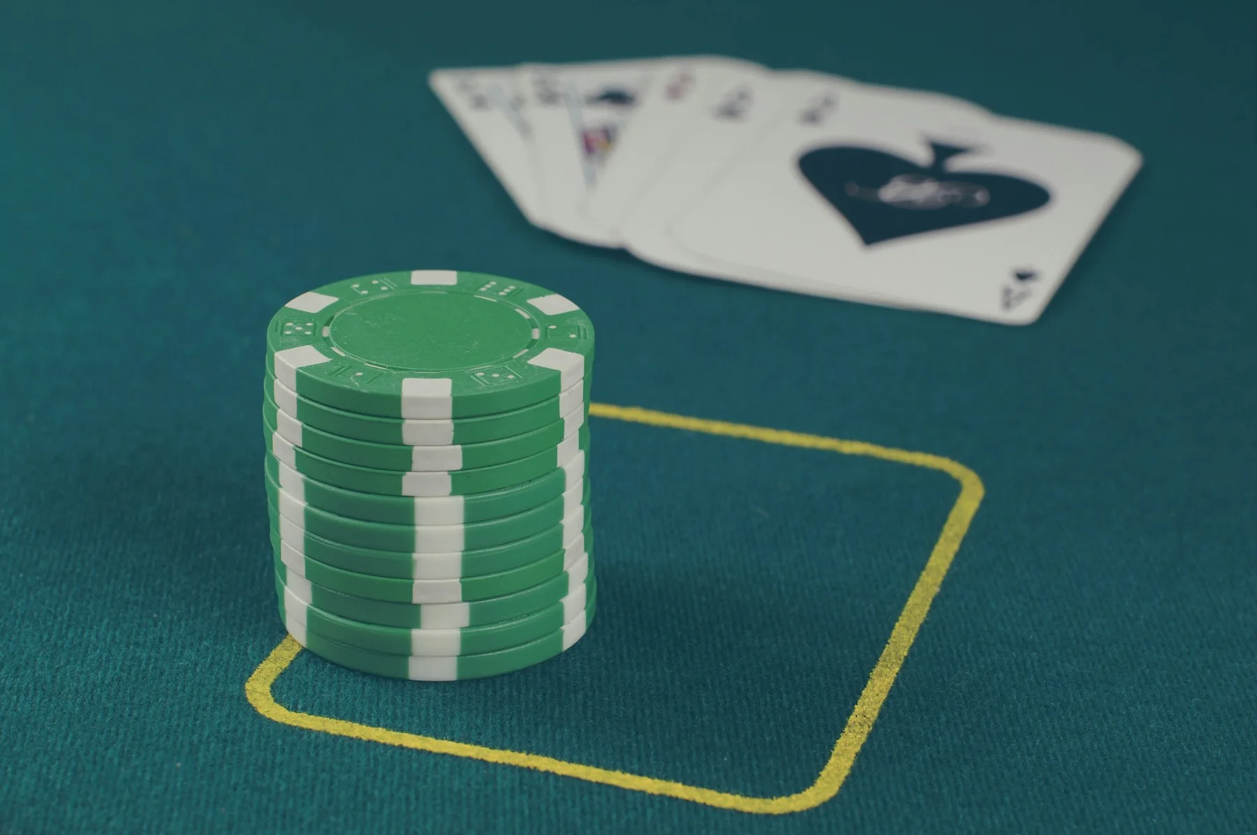 Poker chips and playing cards on a green table